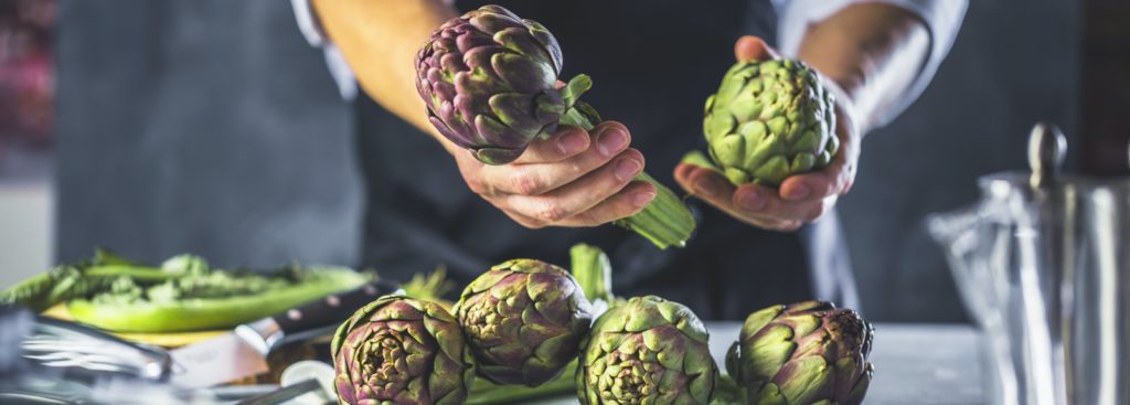 Variedad de alcachofas en la mesa de la cocina